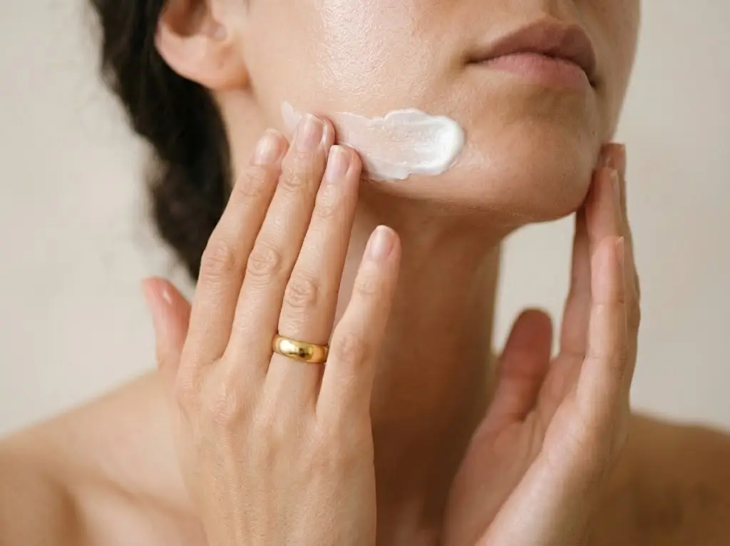 Person applying facial moisturizer as part of a daily skincare routine